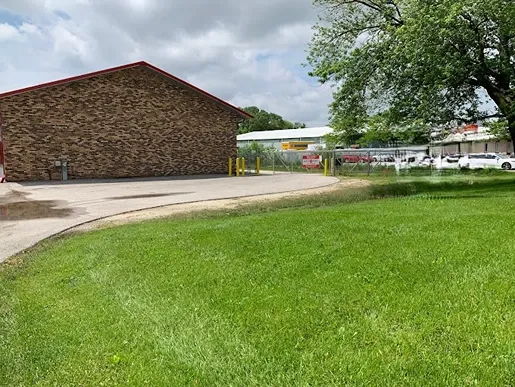Self storage building exterior with surrounding green space and secure perimeter
